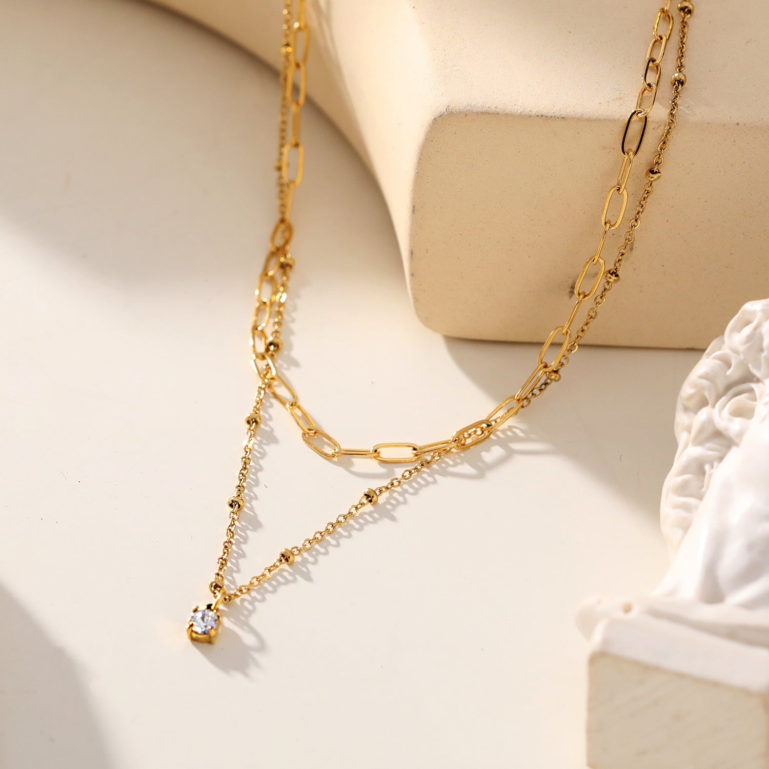 KATERI Gold: Pre-Layered Chains Necklace with a Solitaire Zirconia Charm Pendant.